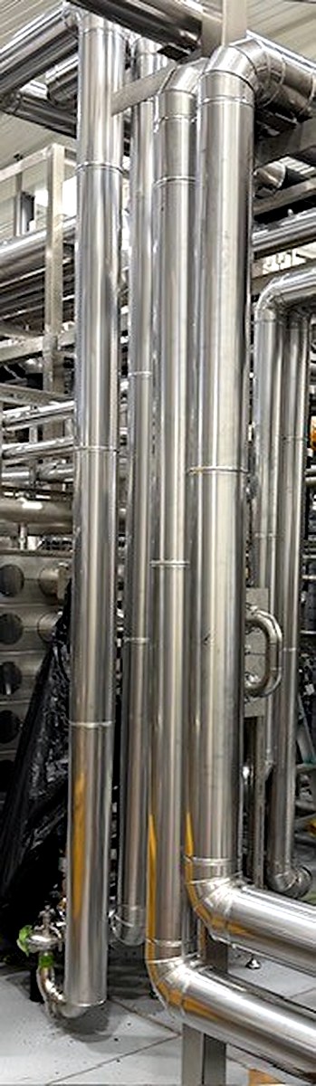 Vertical metal-clad insulated pipework in an industrial process facility